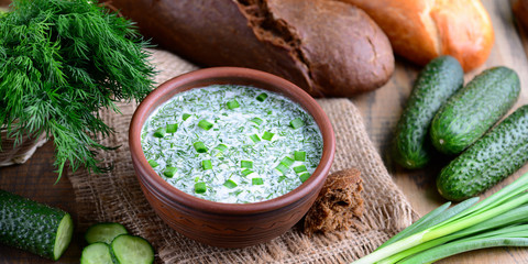 Okroshka. Summer light cold yogurt soup with cucumber,  eggs and dill on a wooden table. A traditional dish of Russian cuisine. 