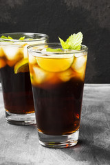 Two glasses of cocktail Cuba Libre on a dark background