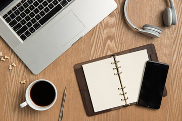 Business planning concept. Top view of hand writing on a blank notebook with hot coffee.