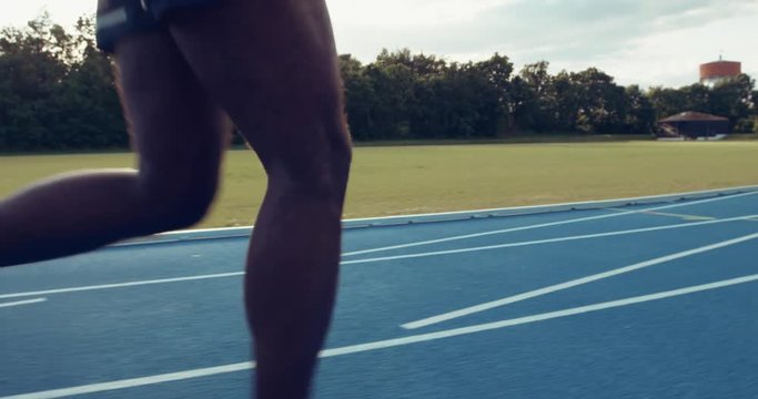 Fit young African athlete sprinting alone down a running track