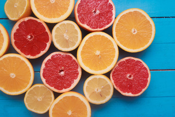 Fresh citrus fruits with green leaves on wooden blue background