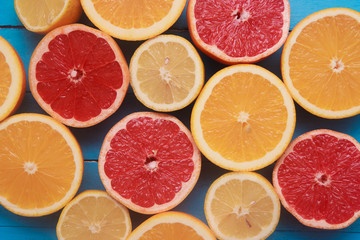 Fresh citrus fruits with green leaves on wooden blue background