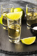 Tequila with lime and salt on a dark background
