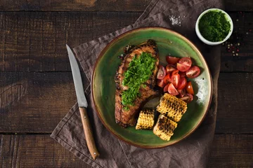 Foto op Canvas Grilled steak with chimichurri sauce and tomatoes over wooden table © kucherav