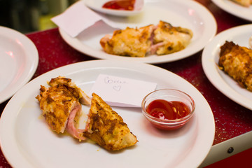 Fried meat rolls in a white plate on a bar rack