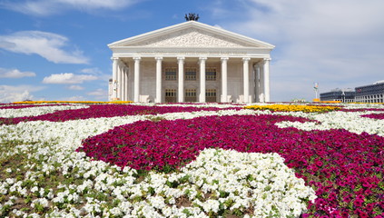 Staatliches Opern- und Balletttheater von Astana mit leuchtend bunten Blumenrabatten im Vordergrund