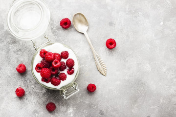 Glanola in glass jar with raspberry and mint on a gray background. Top view, copy space. Food background