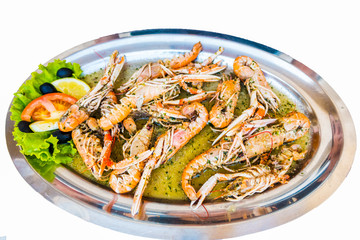 Cooked Scampi Prawns Shrimps in white wine sauce with garlic and parsley, closeup, isolated