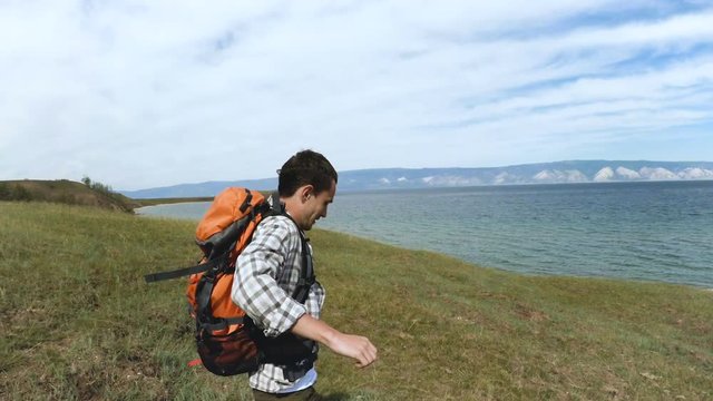 Hiker hiking in Olkhon island in lake Baikal. Hiking man trekking along blue lake Baikal.