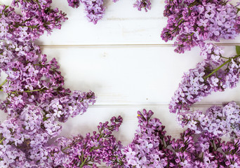 Beautiful purple lilac flower frame on white wooden background 