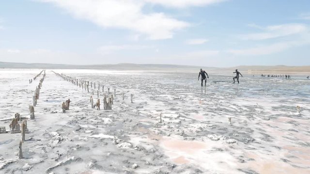Tourists Walking at Lake with White Salty Sea Water. Crimea, Russia.