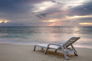 Sunbed with nobody under tropical sunset sky