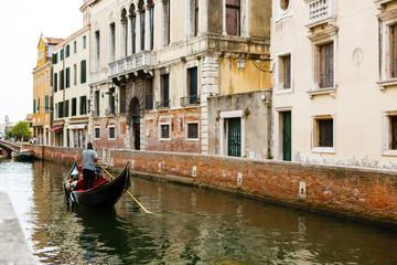Fototapeta na wymiar Gondolier with the typical headgear on a canal of Venice in Italy