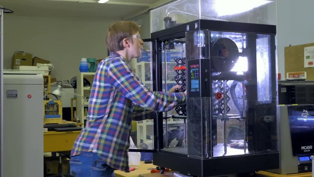 An engineer examines a big mesh 3d-printed piece.  