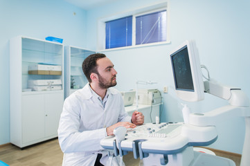 Portrait of a thinking doctor near sceen of medical equipment.