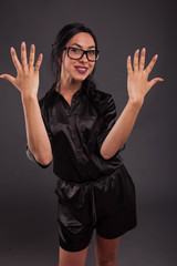 Young cheerful woman portrait of a confident businesswoman showing by hands on a black background. Ideal for banners, registration forms, presentation, landings, presenting concept.