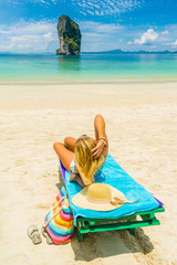 Woman sitting on a bed at the beach