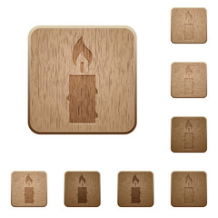 Burning candle with melting wax wooden buttons