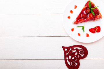 Strawberry pie on white plate and white wooden table. One piece. Top view.  Romantic. Love. Heart.
