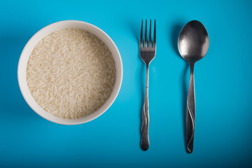 Front view of Raw Rice on bowl in blue background