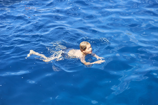 Happy child boy swimming in sea.