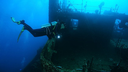 Lonely scuba diver explore the Giannis D wreck with hand light