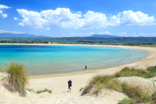 Famous pristine sunny beach Voidokilia in Greece, with beautiful golden beach sand. Summer sunny day skyline scenery. Popular summer resort, travel landmark and vacation destination.