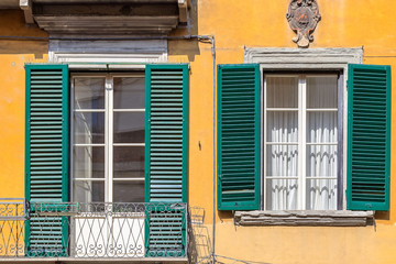 Fototapeta premium Exterior of traditional Italian buildings with green shutters in Florence