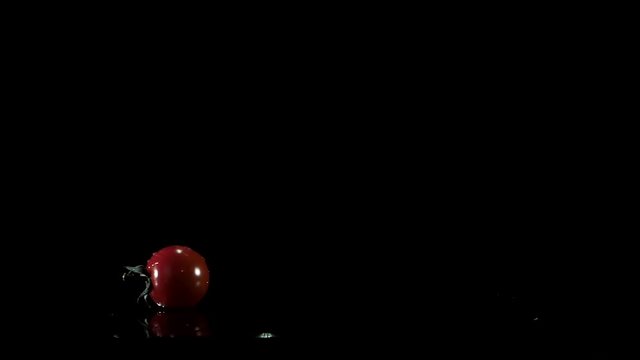 Tomato falls down on the table and spins around.