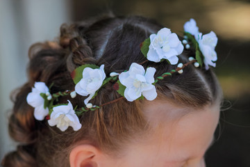 Obraz na płótnie Canvas hair wreath - a stylish accessory on the child's head, wreath of artificial flowers in the hair of a little girl, top view