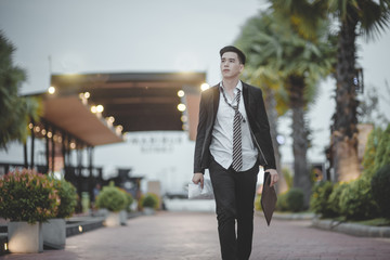 Tired or stressed businessman sitting on the walkway in the city after his work. Image of Stressed businessman concept, young caucasian businessman tired from work sitting at stairs, unemployment.