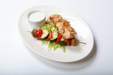 Grilled vegetable and meat skewers on the white background