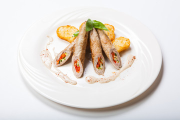 Chicken roll with vegetables on a white table