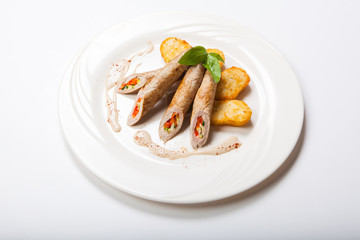 Chicken roll with vegetables on a white table