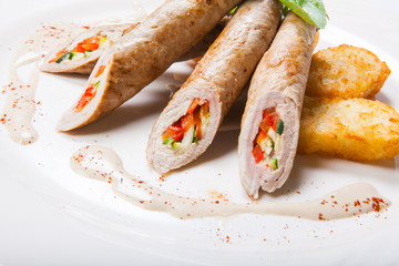 Chicken roll with vegetables on a white table