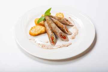 Chicken roll with vegetables on a white table