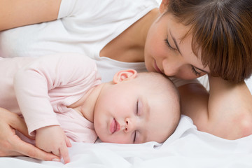 happy mother with her sleeping baby daughter