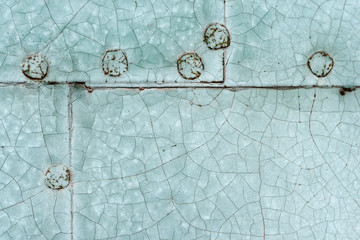 Old blue painted riveted metal door detail