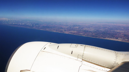 Passenger plane airliner is flying along the sea coast after takeoff.