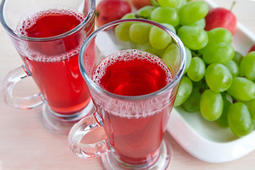 Two glasses of juice and black grapes