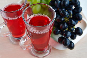 Two glasses of juice and black grapes