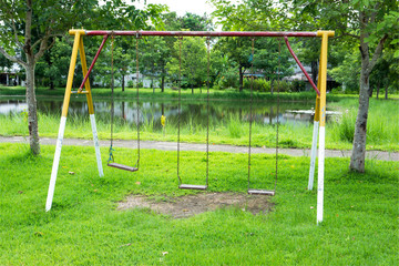 Chain swing in the park.Empty chain swing at the playground with grass background