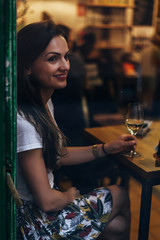 Beautiful woman drinking white wine in a bar.