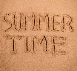 Summer Time written in soft wet sand on a beach