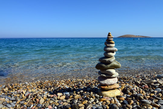 stack of  balanced stones near sea shore, refreshing blue waves summer, beach at the sunset time in Mugla, Turkey