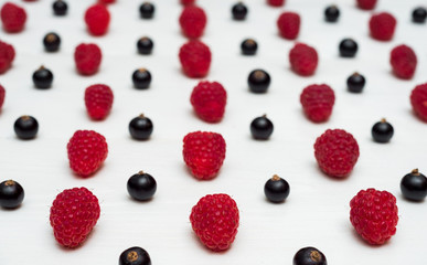 Lines from sweet fresh organic raspberries and blackberries, free space. Fresh berries on white wooden background with blank space. Summer and healthy food concept