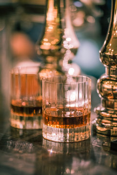 Two glasses with whiskey on the bar, vertical frame