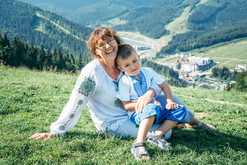 grandmother with kid on the peak of the mountains