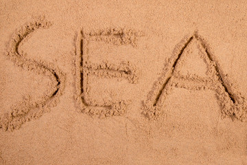 Sea written in soft wet sand on a beach