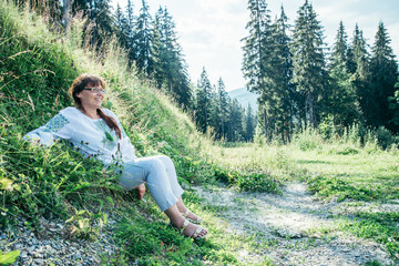 mature woman in national ukrainian clothes in mountains